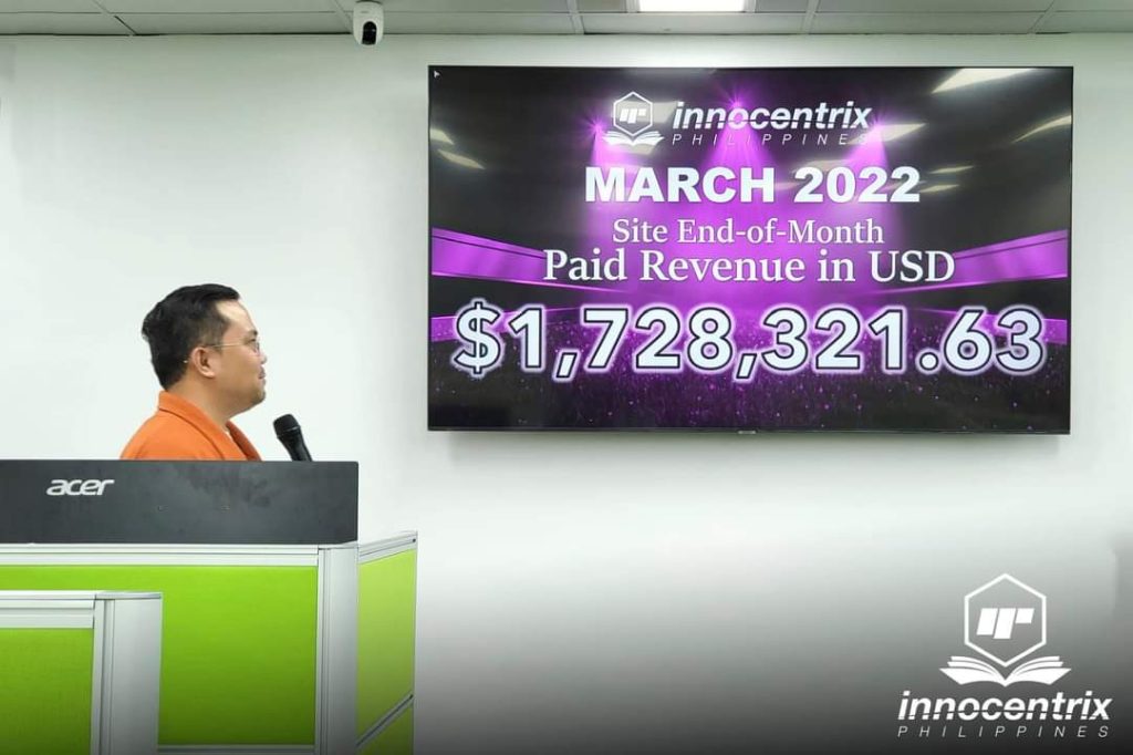 Image of Innocentrix Philippines staff person presenting a revenue report for March 2022 in US dollars, with the dollar figure on a screen behind him: $1,728,321.63