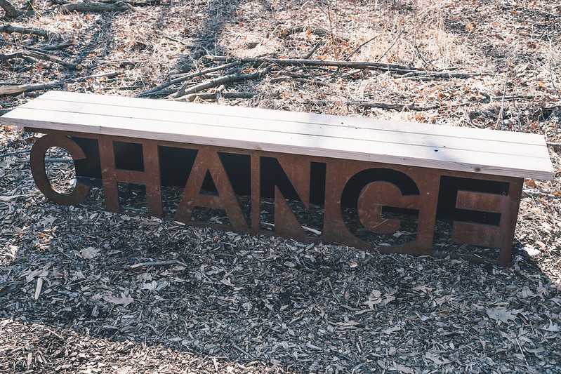 Header image: Wooden bench resting on metal sculpture saying "Change" on a ground of woodchips and fallen leaves. (Credit: Conal Gallagher / https://www.flickr.com/photos/conalg/17250403565/ )